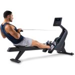 Uomo di lato sul Vogatore NordicTrack RW300 in piena azione di vogata, con schermo. | Allenamento Cardio.