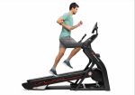 Uomo con maglietta chiara e pantaloncini scuri corre sul Tapis Roulant Elettrico Bowflex Treadmill 25