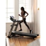 Donna che corre su un Tapis Roulant NordicTrack Elite 1000 in ambiente domestico luminosa
