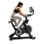 Donna che pedala sulla Spin Bike NordicTrack S10i, vista laterale mentre si allena