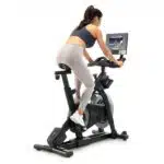 donna che si allena pedalando sulla Spin Bike NordicTrack S10i, vista di schiena