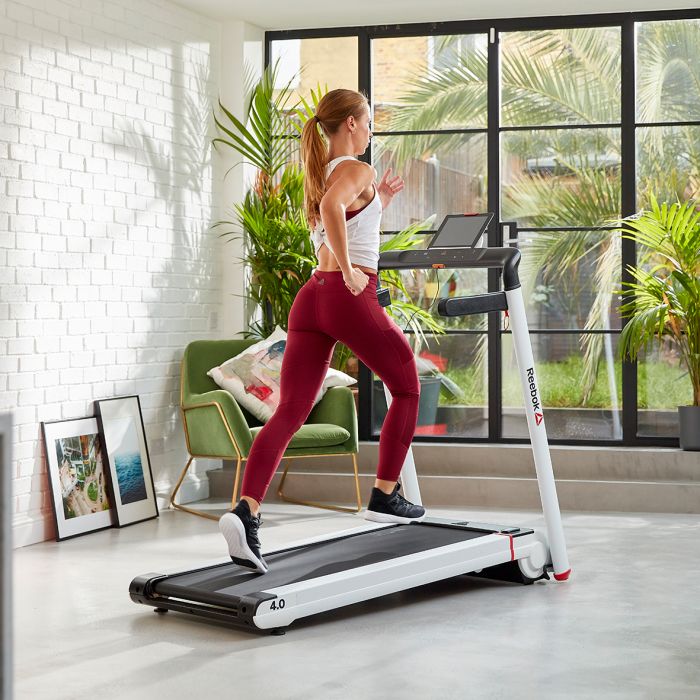 Donna con leggins rossi che corre su nastro del Tapis Roulant Reebok i-Run 4.0