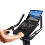 Dettaglio del display LCD e un tablet sulla console della Cyclette Spheris 4.0 NorsK