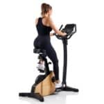 Donna in abbigliamento sportivo si allena sulla Cyclette Spheris 4.0 NorsK