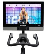 Display touch screen della NordicTrack S27i con trainer sorridente | Interfaccia utente moderna e coinvolgente