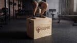 Gambe di un atleta che salta su un Plyo Box Legno fd sport in una palestra | Allenamento pliometrico