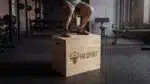 Gambe di un atleta che salta su un Plyo Box Legno fd sport in una palestra | Allenamento pliometrico