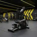 Ellittica BodyJoy CT21PRO in piedi su pavimento nero di una palestra moderna con luci al neon